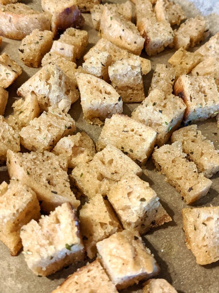 homemade croutons  with spices on parchment paper