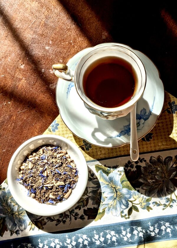 tea cup with spoon and a bowl of loose leaf tea in the sunlight