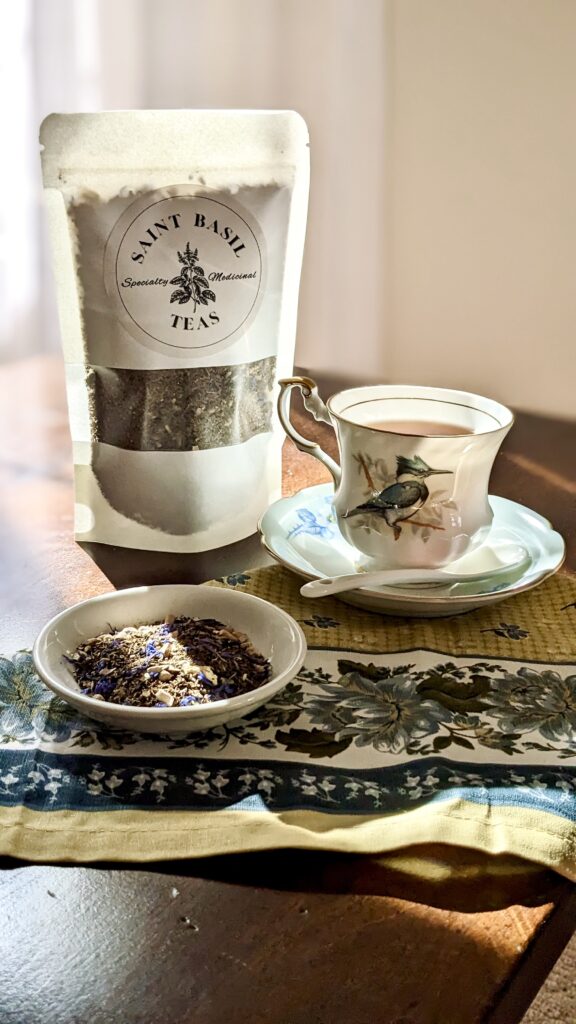 tea cup with bluebird on it and saint basil tea and loose leaf tea in a cup