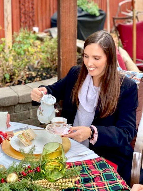 woman pouring tea at christmas themed party