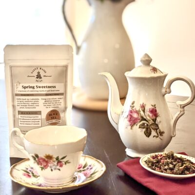 nostalgic tea pot, tea cup, saint basil tea bag and loose leaf tea with flowers