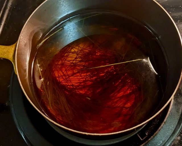 pine needles in a pot of boiling water on stove