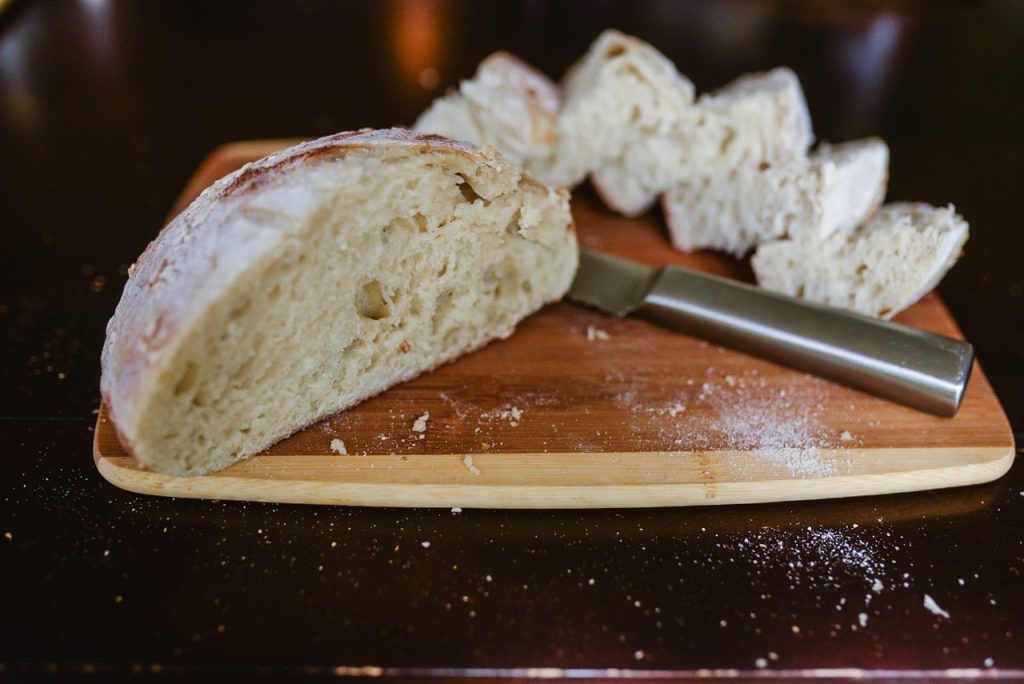 sourdough bread on a cutting board with a bread knife