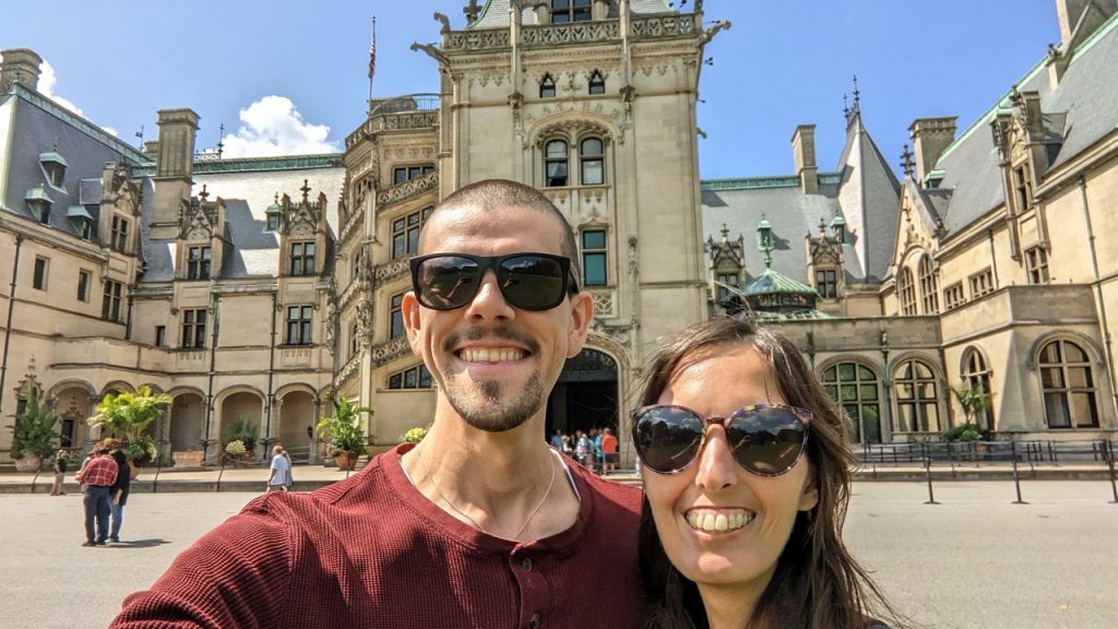 couple smiling in front of Biltmore Estate