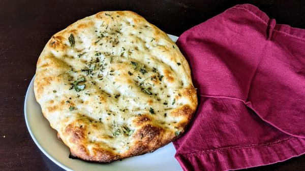 zoomed out angle of sourdough focaccia bread on a plate