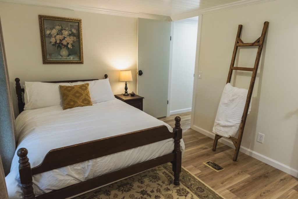 bedroom with a flower painting and blanket ladder