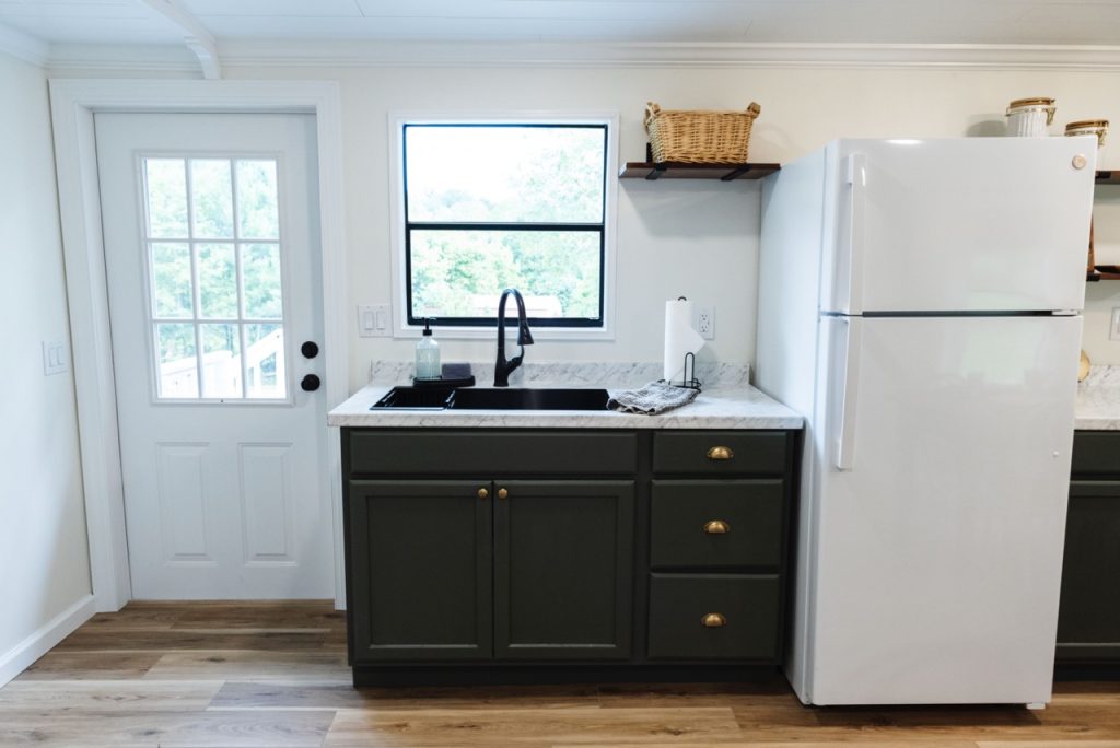 kitchen sink and fridge with cabinets