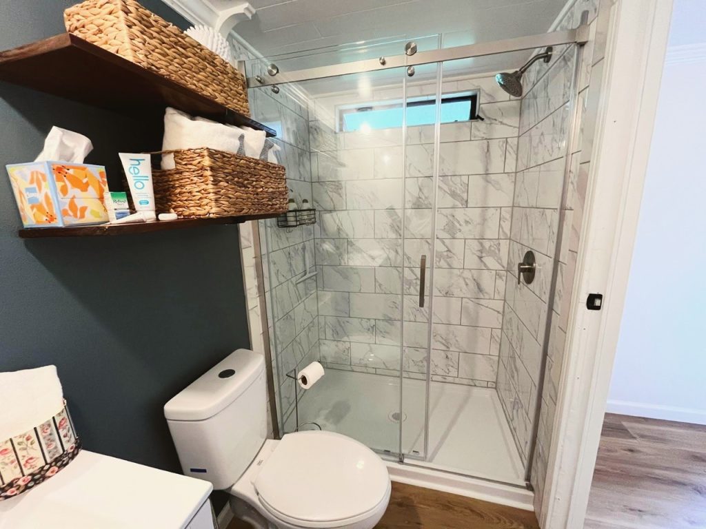 bathroom with vanity and toilet, baskets and shower