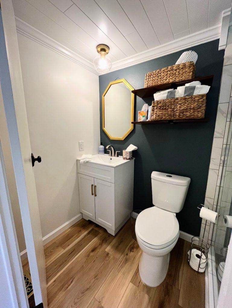 bathroom with vanity and toilet and baskets and mirror